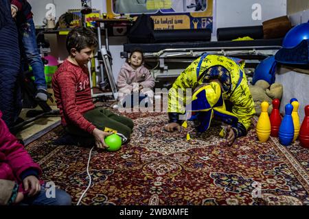 Idlib, Syrien. Januar 2024. Firas Al-Ahmad, als Clown gekleidet, spielt mit Kindern während eines Unterhaltungsprogramms im Rahmen des psychologischen Unterstützungsprogramms für Kinder an der Step of Hope School in Idlib. Die STEP of Hope School für Menschen mit besonderen Bedürfnissen und kriegsverwundete Kinder zielt darauf ab, Kinder mit besonderen Bedürfnissen in die Gesellschaft zu integrieren. Anas Alkharboutli/dpa/Alamy Live News Stockfoto