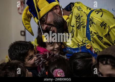 Idlib, Syrien. Januar 2024. Firas Al-Ahmad, als Clown gekleidet, spielt mit Kindern während eines Unterhaltungsprogramms im Rahmen des psychologischen Unterstützungsprogramms für Kinder an der Step of Hope School in Idlib. Die STEP of Hope School für Menschen mit besonderen Bedürfnissen und kriegsverwundete Kinder zielt darauf ab, Kinder mit besonderen Bedürfnissen in die Gesellschaft zu integrieren. Anas Alkharboutli/dpa/Alamy Live News Stockfoto