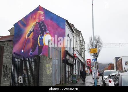 Das neue Wandbild der Shankill Road wurde zur Verbesserung der Gegend vorgestellt. Ein junger Schlagzeuger bringt einen lebendigen Farbtupfer mit, gemalt vom Straßenkünstler Glen Mo Stockfoto