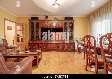 Vorderbild eines Wohnzimmers in einem Haus mit klassischen Holzmöbeln mit einem Esstisch mit passenden Stühlen, einem hölzernen Sideboard, das einen bedeckt Stockfoto