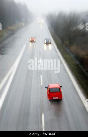 Geisterfahrer in rotem Kleinwagen in falscher Richtung auf der Autobahn, Autobahn bei München, Bayern, Deutschland, digitales Compositing Stockfoto