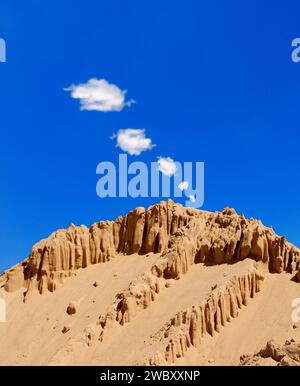 Ein sandiger, felsiger Berg, Rauchsignale am blauen Himmel Stockfoto