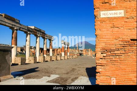 Ruinen von Pompeji oder Pompeji mit Vesuv im Hintergrund mit Straßenschild in lateinischer Sprache in der Metropolstadt Neapel, Italien, Europa Stockfoto