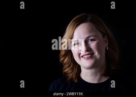 Porträt der schönen glücklichen lächelnden Frau auf dunkelschwarzem Hintergrund. Nahaufnahme Porträt einer glücklichen weißen Frau in dezentem Ton. Kopierbereich für den Text. Stockfoto