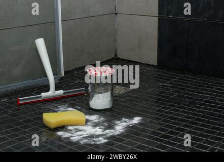 Backpulver, Schwamm und ein Duschtuch auf gefliestem Duschboden, umweltfreundliche Reinigung Stockfoto
