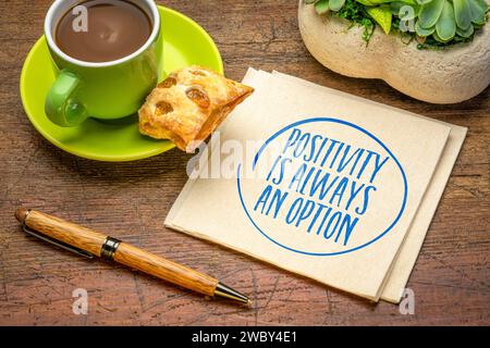 Positivität ist immer eine Option – inspirierende Erinnerungsnotiz auf einer Serviette mit Kaffee, positiver Einstellung und Verhaltenskonzept Stockfoto