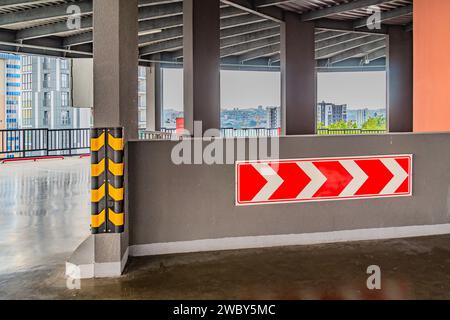 Schild für Umlenkung von Verkehr und Reifen als Hindernisse auf einer Straßenbaustelle. Unter der Brücke befindet sich ein rotes Warnschild auf der Brücke. Weiß und Stockfoto