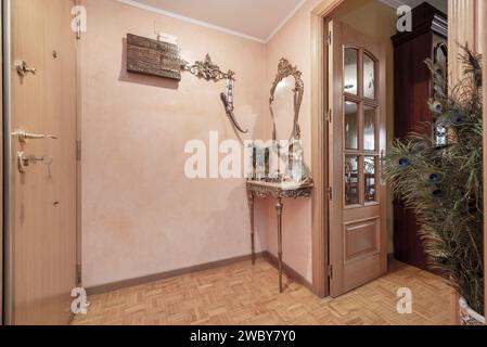 Wohnbereich mit dekorativen Möbeln und passendem Spiegel in Silber- und Eichenparkett Stockfoto