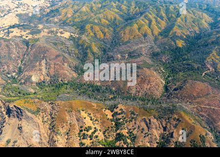 Blick aus der Vogelperspektive auf das farbenfrohe Muster und Relief der Bergkämme und sanften Hügel Stockfoto