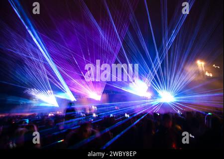 Bunte Lichtshow bei Nacht. Laserlichter und Nebel auf der Bühne während des Konzerts. Laserstrahlen auf dem Festival. Abstrakter Hintergrund. Stockfoto