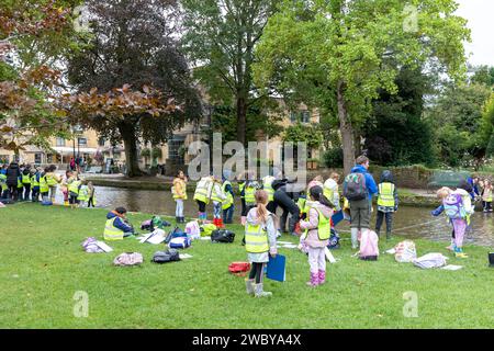 Bourton on the Water Village, kleine Kinder aus der örtlichen Grundschule auf Schulausflug und lernen mehr über den Fluss windrush, Gloucestershire, England, Großbritannien Stockfoto