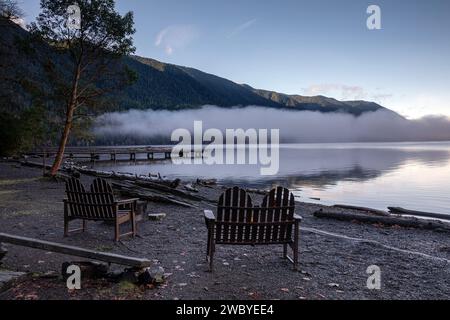 WA23924-00...WASHINGTON - Outdoor Stühle und ein Pier am Ufer des Lake Crescent an einem nebeligen Morgen in der Lake Crescent Lodge. Stockfoto