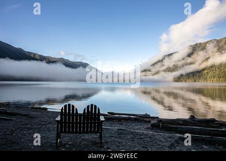 WA23925-00...WASHINGTON - Outdoor-Stuhl am Ufer des Lake Crescent an einem nebeligen Morgen in der Lake Crescent Lodge. Stockfoto