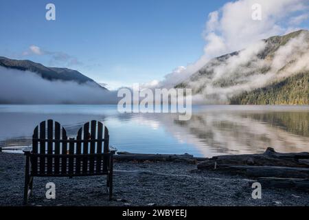 WA23926-00...WASHINGTON - Outdoor-Stuhl am Ufer des Lake Crescent an einem nebeligen Morgen in der Lake Crescent Lodge. Stockfoto