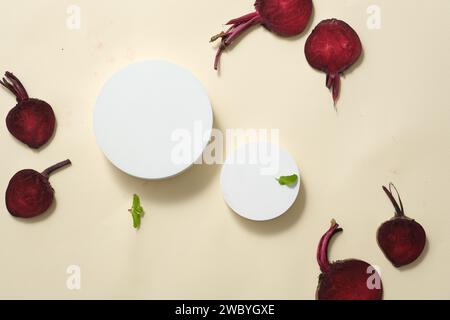 Ein Satz weißer Podeste in runder Form, dargestellt mit Roter Bete und grünen Blättern. Moderne Minimal-Showcase-Szene für Werbeaktionen für kosmetische Produkte Stockfoto