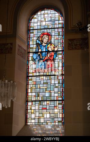 Der heilige Josef mit dem kleinen Jesus. Ein Buntglasfenster in der Eglise de la Sainte-Trinité (Heilige Dreifaltigkeitskirche) in Walferdange, Luxemburg. Stockfoto