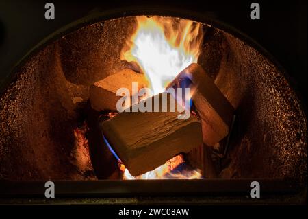 Holzbriketts (Typ ruf) aus Buchen- und Eichenholz, die im Brennkessel verbrannt werden. Alternativer Kraftstoff, umweltfreundlicher Kraftstoff, Biokraftstoff. Stockfoto