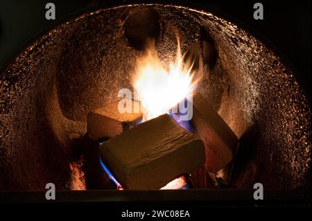 Holzbriketts (Typ ruf) aus Buchen- und Eichenholz, die im Brennkessel verbrannt werden. Alternativer Kraftstoff, umweltfreundlicher Kraftstoff, Biokraftstoff. Stockfoto