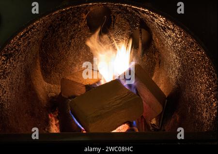 Holzbriketts (Typ ruf) aus Buchen- und Eichenholz, die im Brennkessel verbrannt werden. Alternativer Kraftstoff, umweltfreundlicher Kraftstoff, Biokraftstoff. Stockfoto