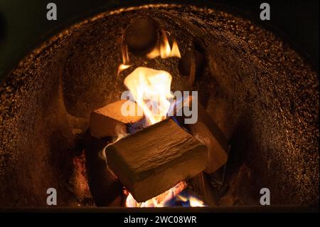 Holzbriketts (Typ ruf) aus Buchen- und Eichenholz, die im Brennkessel verbrannt werden. Alternativer Kraftstoff, umweltfreundlicher Kraftstoff, Biokraftstoff. Stockfoto