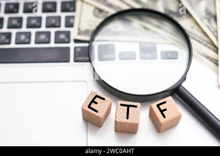 ETF geschrieben auf Holzwürfel mit Tastatur, Rechner, Karte, Brille. Business Stockfoto