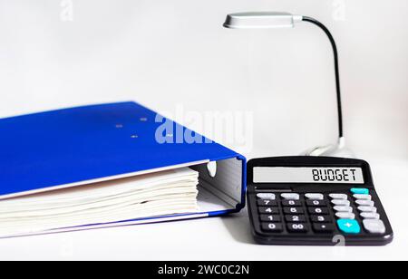 Budgetierung und Budgetberechnung oder -Analyse. Worthaushalt auf Taschenrechner und weißem Hintergrund Stockfoto