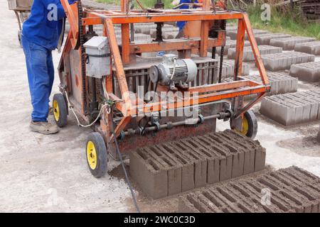 afrikanische man Ziegelbaumaschine, hergestellt aus Zementbeton und Sand Stockfoto