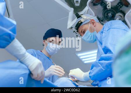 Männliche Chirurgen führen Operationen im Operationssaal durch, plastischer Chirurg im Operationssaal Stockfoto