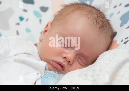 Das Gesicht eines schlafenden Neugeborenen. Das Baby schlief süß auf dem Kissen ein. Stockfoto