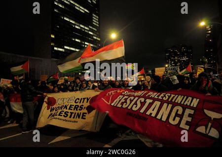 Demonstranten marschieren vor dem Gebäude der Vereinten Nationen, während sie Banner halten, die palästinensischen, jemenitischen und südafrikanischen Flaggen schwenken und Plakate bei einer Kundgebung zur Unterstützung des Jemen und Palästinas tragen. Hunderte Demonstranten marschierten in Manhattan, New York City, um die US-amerikanischen und britischen Militärs zu verurteilen, die am Donnerstag, dem 11. Januar, Luftangriffe gegen Houthi-Ziele im Jemen starteten. Die Demonstranten verlangten auch einen dauerhaften Waffenstillstand im Krieg zwischen Israel und der Hamas und ein Ende der Bombardierung des israelischen Militärs auf Gaza. Laut US-Präsident Joe Biden, die Luftangriffe vom 11. Januar im Jemen'AR Stockfoto