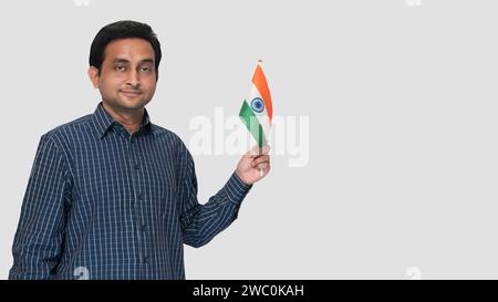 26. Januar in Indien schwenkte ein junger Indianer die Nationalflagge in der Hand. Stockfoto