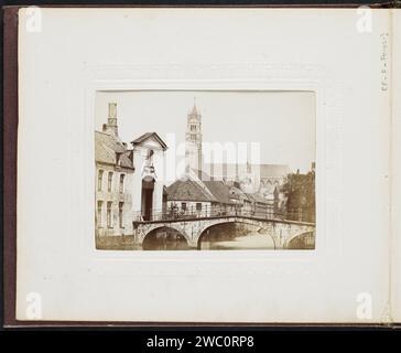 Blick auf ein Tor, eine Brücke und die Sint-Salvators-Kathedrale in Brügge, Victor Daveluy, 1871 - ca. 1872 Foto links das Eingangstor des Begijnhofs mit den Worten Sauve Garde und das Jahr 1776 darüber. Im Vordergrund die Weinbergsbrücke über den Minnewater. Im Hintergrund die Kathedrale Sint-Salvators. Dieses Foto ist Teil eines Albums. Albumendruck aus gebrauchtem Papier im Allgemeinen: „Veduta“. Brücke. Teile der Kirche außen und Nebengebäude: turm. Alms-House (Niederländisch: 'Hofje') (+ Variante) Kathedrale Sint-Salvators. Beguinage Stockfoto