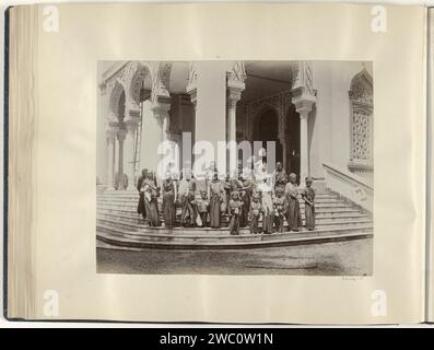 Gruppenporträt von Frauen und Kindern auf der Treppe der großen Moschee von Banda Aceh, Anonym, ca. 1895 - ca. 1905 Fotografie Teil von Reisalbum mit Fotos von Sehenswürdigkeiten in Italien, der Schweiz und Niederländisch-Indien. Banda Atjeh Papier. Fotografischer Trägeralbumendruck Mutter und Baby oder Kleinkind. Tempel, Schrein  Islam, Mohammedanismus Banda Atjeh Stockfoto