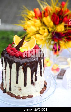 Kindergeburtstag. Ein festlicher Tisch mit Geburtstagskuchen mit Blumen und Süßigkeiten. Stockfoto
