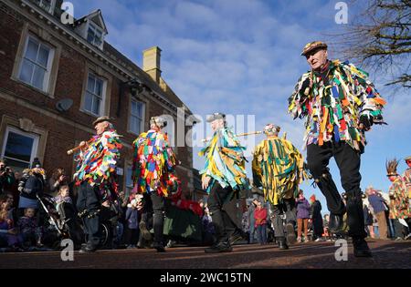 Morris-Tänzer treten auf, während der Strohbär während des Whittlesea Straw Bear Festival in Whittlesea, Cambridgeshire, durch die Straßen gleitet. Bilddatum: Samstag, 13. Januar 2024. Stockfoto