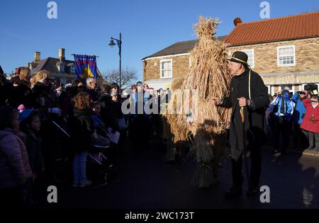 Der Strohbär wird während des Whittlesea Straw Bear Festivals in Whittlesea, Cambridgeshire, begleitet von Pflegern, Musikern und Tänzern durch die Straßen geführt. Bilddatum: Samstag, 13. Januar 2024. Stockfoto