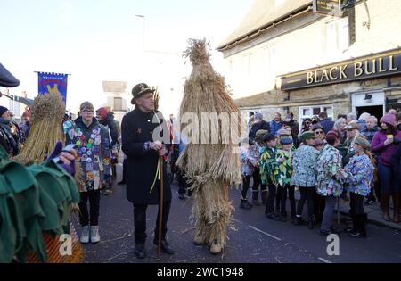 Der Strohbär wird während des Whittlesea Straw Bear Festivals in Whittlesea, Cambridgeshire, begleitet von Pflegern, Musikern und Tänzern durch die Straßen geführt. Bilddatum: Samstag, 13. Januar 2024. Stockfoto