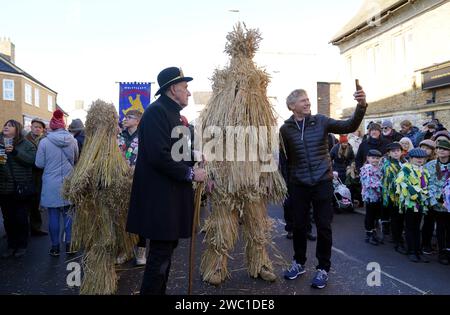 Der Strohbär wird während des Whittlesea Straw Bear Festivals in Whittlesea, Cambridgeshire, begleitet von Pflegern, Musikern und Tänzern durch die Straßen geführt. Bilddatum: Samstag, 13. Januar 2024. Stockfoto