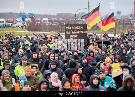 Hohenlockstedt, Deutschland. Januar 2024. Die Teilnehmer einer Demonstration halten deutsche Fahnen und ein Banner mit der Aufschrift "Wir sorgen für Wohlstand, nicht die Politiker". Auf dem Flugplatz Hungry Wolf. Der Schleswig-Holsteinische Baugewerbeverband forderte eine große Demonstration von Bauunternehmen. Quelle: Georg Wendt/dpa/Alamy Live News Stockfoto