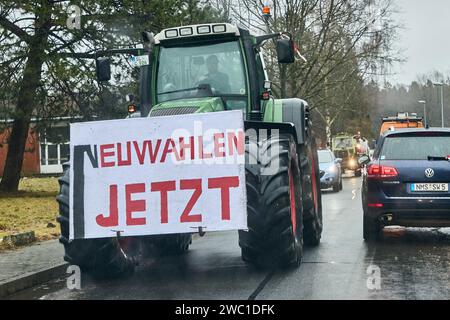 Hohenlockstedt, Deutschland. Januar 2024. Ein Traktor mit dem Banner „neue Wahlen jetzt“ fährt in einem Konvoi zum Flugplatz Hungry Wolf. Der Schleswig-Holsteinische Baugewerbeverband forderte eine große Demonstration von Bauunternehmen. Quelle: Georg Wendt/dpa/Alamy Live News Stockfoto