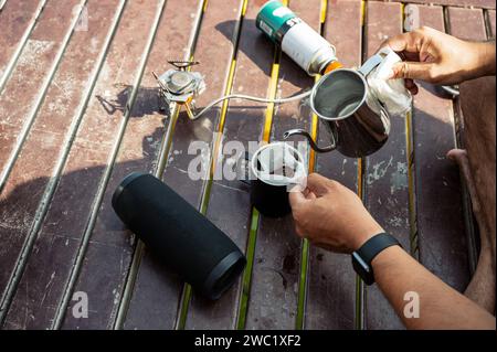 Gießen Sie heißes Wasser aus dem Wasserkocher in gemahlenen Kaffee auf einer Tasse. Morgens tropfenden Kaffee zubereiten Stockfoto