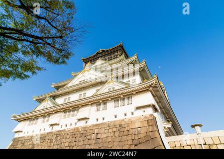 Die Burg Osaka wurde im Borogata-Stil auf der Ishigaki-Steinbasis erbaut, die über dem Betrachter thront, und an einem sonnigen Frühlingstag vor einem klaren blauen Himmel. Stockfoto