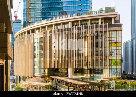 Sonnendurchfluteter Einkaufskomplex „Grand Front Osaka“, mit Verbindungsbrücke zur Halle des Nordgebäudes des des Bahnhofs Osaka während der Hauptverkehrszeit am Nachmittag. Stockfoto