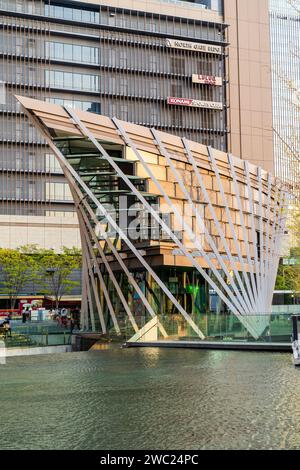 Umekita Ship Hall und Wasserspiel mit dem Nordtor der Osaka Station City dahinter, beleuchtet von der untergehenden Sonne (ungesehen). Komprimierte Perspektive. Stockfoto