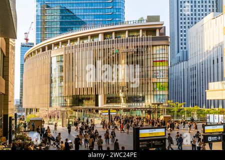 Sonnendurchfluteter Einkaufskomplex „Grand Front Osaka“ und im Vordergrund die Halle des Nordens der Osaka Station, die während der Hauptverkehrszeit am Nachmittag beschäftigt ist. Stockfoto