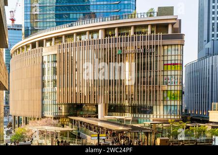 Sonnendurchfluteter Einkaufskomplex „Grand Front Osaka“, mit Verbindungsbrücke zur Halle des Nordgebäudes des des Bahnhofs Osaka während der Hauptverkehrszeit am Nachmittag. Stockfoto