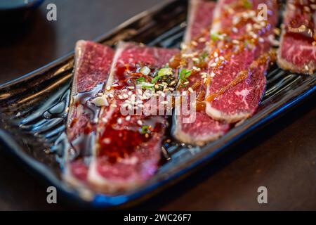 Crosscut Short Ribs Rindfleisch mit Sauce auf Teller, Rindfleisch Short Ribs auf Teller, Premium japanisches Fleischkonzept. Weichzeichner Stockfoto