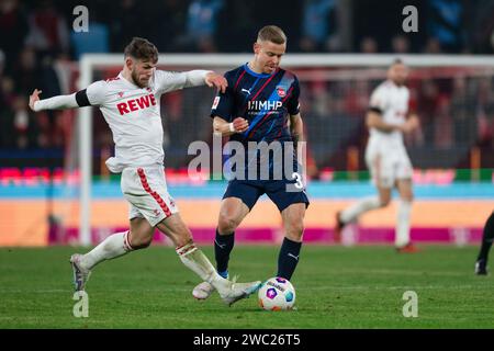 Köln, Deutschland. Januar 2024. Fußball, Bundesliga, Spieltag 17, 1. FC Köln - 1. FC Heidenheim, RheinEnergieStadion: Kölner Jan Thielmann (l) und Heidenheims Lennard Maloney kämpfen um den Ball. Hinweis: Marius Becker/dpa – WICHTIGER HINWEIS: gemäß den Vorschriften der DFL Deutscher Fußball-Liga und des DFB Deutscher Fußball-Bundes ist es verboten, im Stadion und/oder des Spiels aufgenommene Fotografien in Form von sequenziellen Bildern und/oder videoähnlichen Fotoserien zu verwenden oder zu nutzen./dpa/Alamy Live News Stockfoto