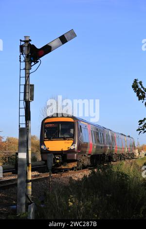 170618 C2C-Zug, der ein Semaphore-Signal überquert, in Whittlesey Town, Fenland, Cambridgeshire, England Stockfoto