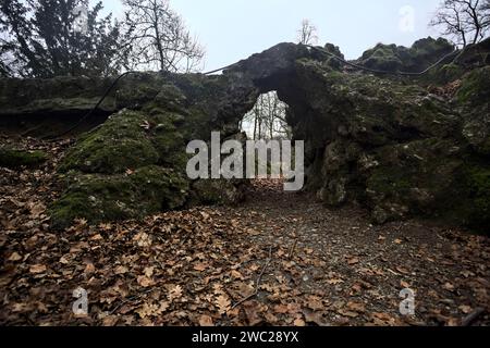 Passage unter einer Felsformation in einem Park an einem bewölkten Tag im Herbst Stockfoto